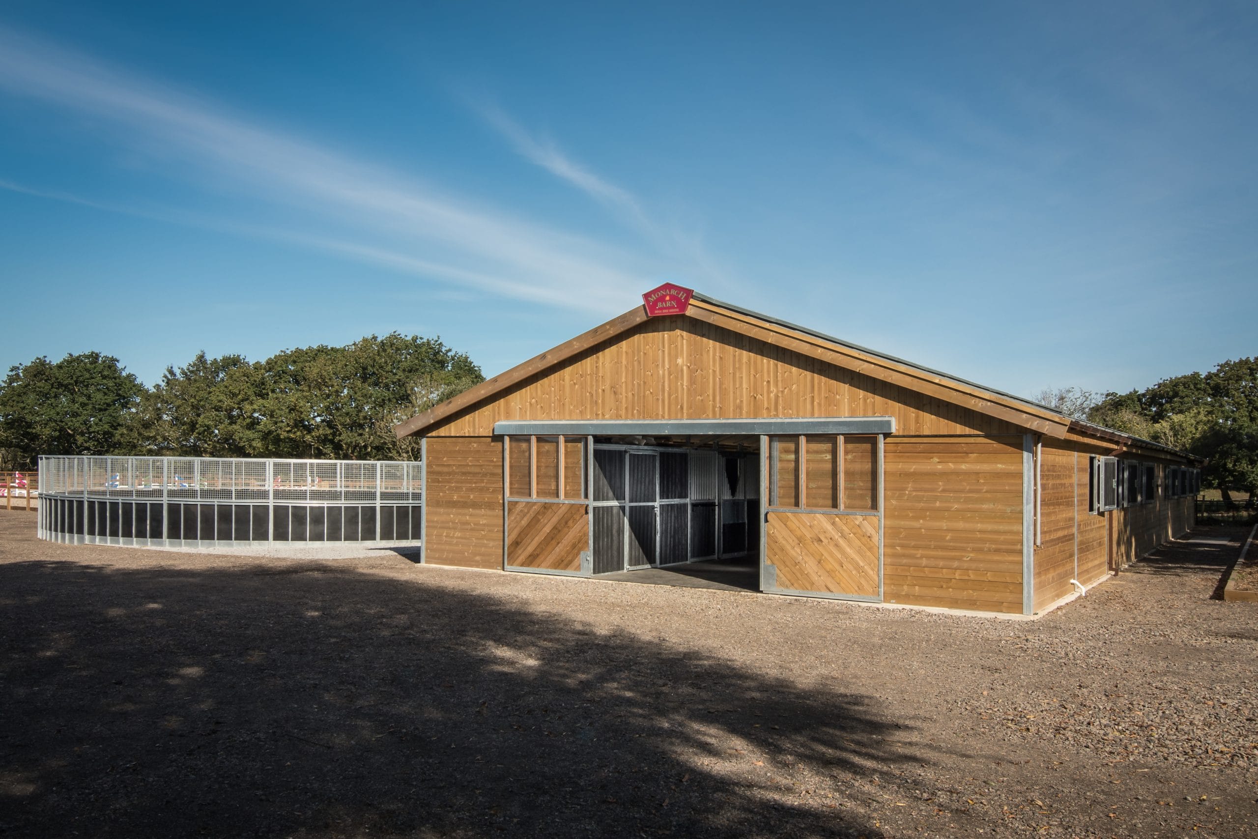 Wide view of a Monarch Barn showcasing its twin skin design and insulated walls, surrounded by a Lunge Pen
